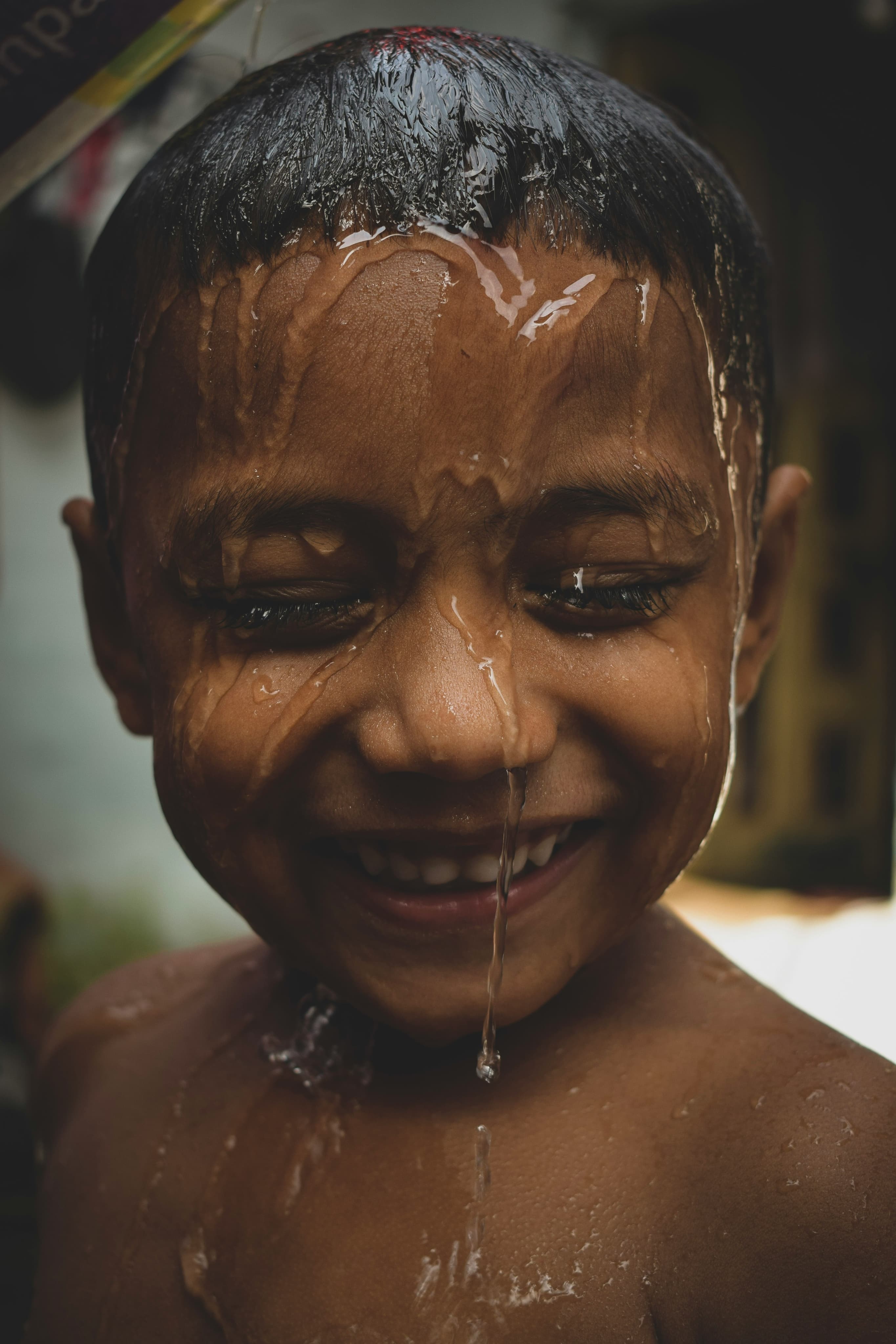 Smiling child with clean water on their face